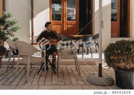 Tourist man having a coffee in a cafe in tourist area in Albania. Tourist man having a coffee in a cafe in tourist area in Albania. 99541659