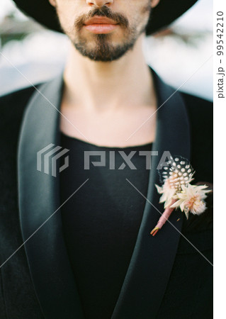Boutonniere is pinned to the groom jacket. Close-up Boutonniere is pinned to the groom jacket. Close-up 99542210