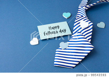 Happy fathers day card with tie and love heart on blue background with copy space Happy fathers day card with tie and love heart on blue background with copy space 99543593