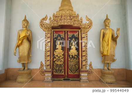 Traditional Thai art pattern made of wood and two Buddhas decorated at the Thai Church door at Wat Somdet, a historic site in Amphoe Sangkhlaburi, Kanchanaburi Province , Middle of Thailand.  99544049