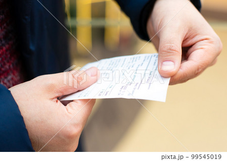 paper grocery shopping receipt in male hands close-up. Blank check from shop, supermarket or restaurant. 99545019