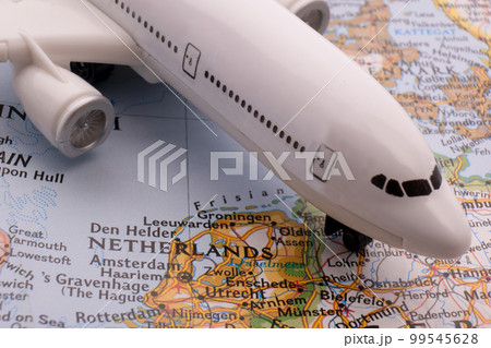 Close up of a miniature passenger plane on a colorful map showing Amsterdam, Netherlands through selective focus, background blur. High quality photo 99545628