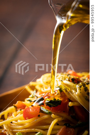 パスタにオリーブオイルをかける 99545955