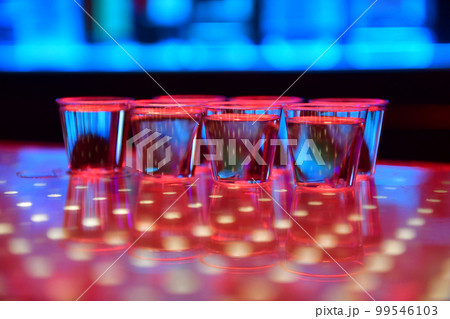 Vodka or tequila shots on bar counter in night club 99546103