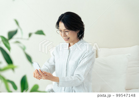 メガネをかけてスマホを見るミドル女性 メガネをかけてスマホを見るミドル女性 99547148