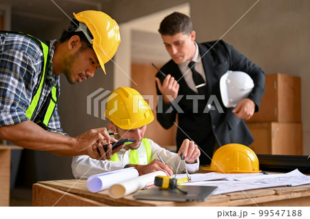 A professional Asian male construction inspector using scientific calculator. A professional Asian male construction inspector using scientific calculator. 99547188