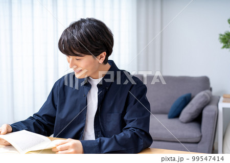 リビングで読書をする若い男性 リビングで読書をする若い男性 99547414