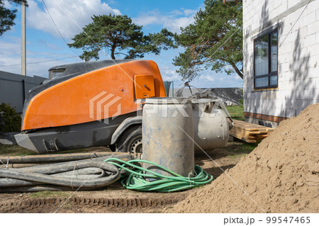 Machine with mixer isinstallation for feeding cement mixture for pouring semi-dry floor screed in house. Construction site with slide of sand, preparation for leveling the rough floor of cottage Machine with mixer isinstallation for feeding cement mixture for pouring semi-dry floor screed in house. Construction site with slide of sand, preparation for leveling the rough floor of cottage 99547465