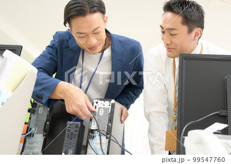 オフィスのPC配線をつなぐ情報システム担当者　情シス　ビジネスイメージ 99547760