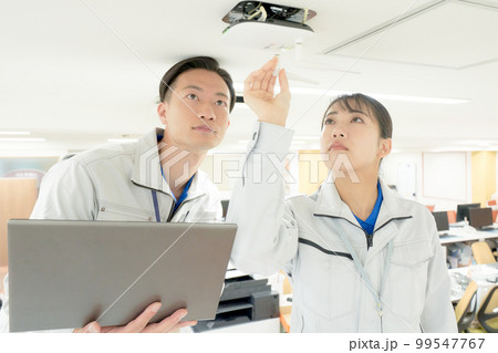 オフィスのWi-Fiをチェックする作業服のスタッフ　ビジネスイメージ 99547767