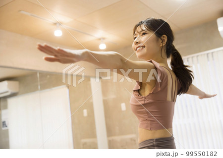 フィットネスジムでヨガをやる若い女性 99550182