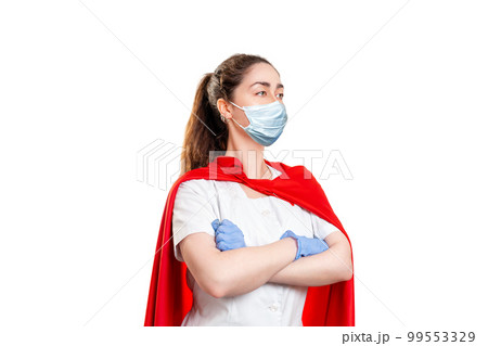 A doctor wearing in a medical face mask, gloves and a superhero Cape, ready to work. Isolated on white background. The concept of the Power of a super hero for medicine A doctor wearing in a medical face mask, gloves and a superhero Cape, ready to work. Isolated on white background. The concept of the Power of a super hero for medicine 99553329