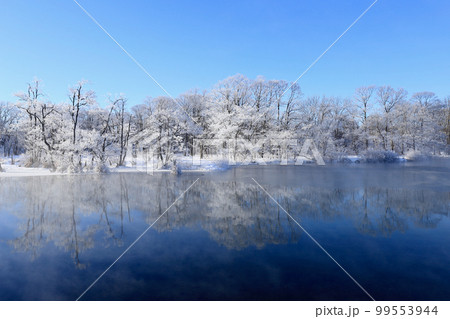 霧氷で真っ白になった木々が美しく水面に映るの写真素材 [99553944