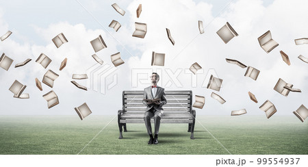 Young businessman or student studying the science and books fly around 99554937