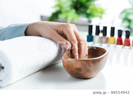 Closeup female hands in wooden bowl with water Closeup female hands in wooden bowl with water 99554942