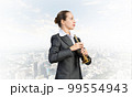 Business woman playing the trumpet 99554943