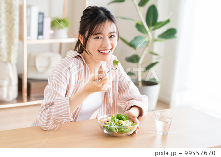 アボカドサラダを食べる若い女性 99557670