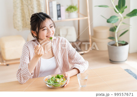 アボカドサラダを食べる若い女性 99557671