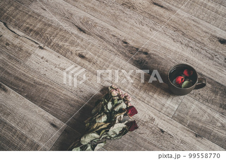 木目の背景と花びらが入ったコーヒーカップ 木目の背景と花びらが入ったコーヒーカップ 99558770