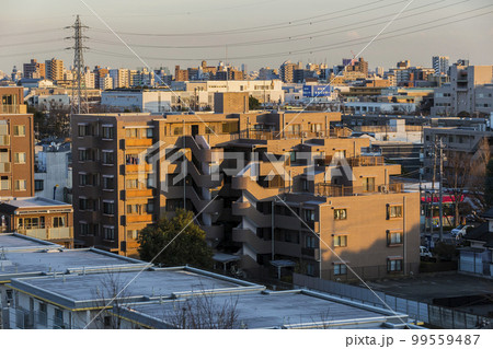 夕日の空　夕焼け　建物　マンション　黄昏　西日　雲　空　オレンジ色 99559487