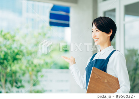 カフェの前でお客様を迎えるミドル女性 カフェの前でお客様を迎えるミドル女性 99560227