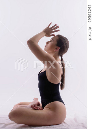 Image of young plump female doing acrobatic stunt, studio shot 99561242