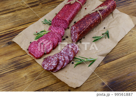 Salami sausages on craft paper on a wooden table 99561887