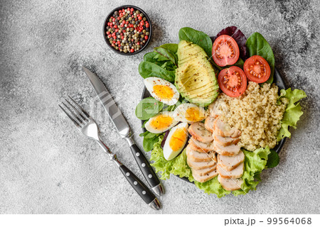 Delicious healthy lunch consisting of chicken, avocado, quinoa, eggs, tomatoes 99564068