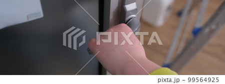 Closeup of woman hand holding and pushing doorknob 99564925
