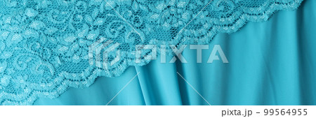 Delicate light blue guipure lace fabric on blue satin fabric Delicate light blue guipure lace fabric on blue satin fabric 99564955