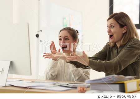 Women in office rejoice while looking at computer screen Women in office rejoice while looking at computer screen 99564967