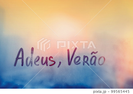 lettering Adeus Verao in Portuguese language is good bye summer in english on foggy glass on sunset window lettering Adeus Verao in Portuguese language is good bye summer in english on foggy glass on sunset window 99565445