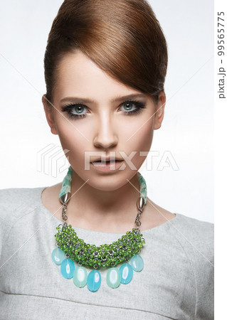 Beautiful fashionable girl with smooth hair and original decoration around her neck. Model in white. Beauty face. Beautiful fashionable girl with smooth hair and original decoration around her neck. Model in white. Beauty face. 99565775
