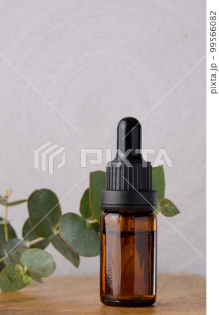 Brown glass bottle with pipette for cosmetic procedures on a wooden background 99566082