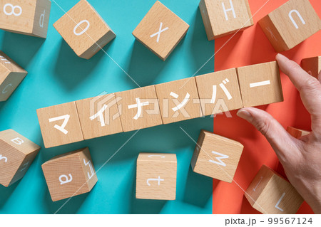 マイナンバーと書かれたブロックと手 99567124