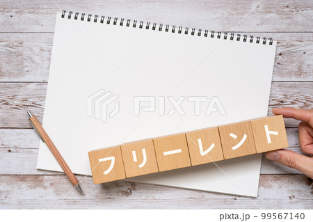 フリーレントと書かれたブロック、ノート、ペン、手 99567140