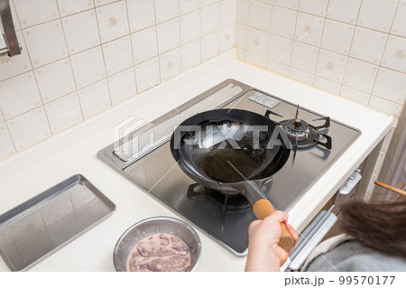 【レバニラ炒めを作る　中華鍋に多めの油をなじませる】 99570177