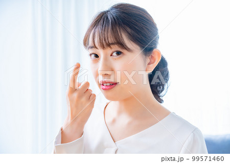 コンタクトレンズをつけようとする女性 コンタクトレンズをつけようとする女性 99571460