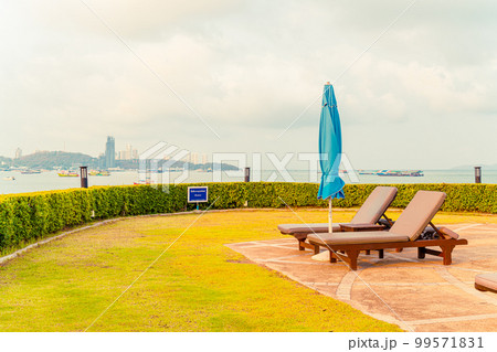 chair pool or bed pool and umbrella around swimming pool with sea beach background 99571831