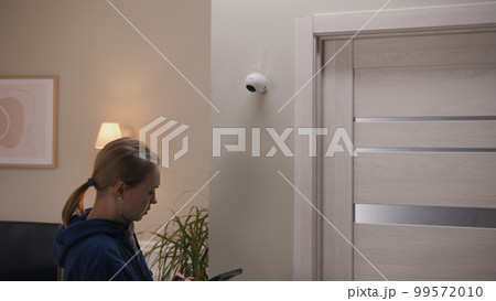 Woman sets up CCTV camera using tablet Woman sets up CCTV camera using tablet 99572010