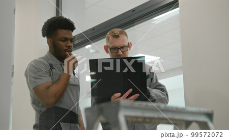 Installers sets up security cameras in office 99572072