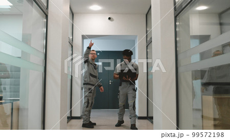 Men install CCTV cameras in office corridor Men install CCTV cameras in office corridor 99572198