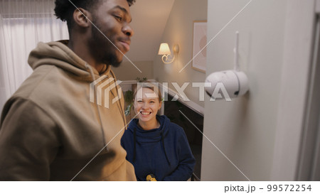 African American man installs security camera African American man installs security camera 99572254