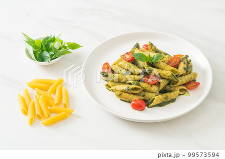 penne pasta with pesto sauce and tomatoes 99573594