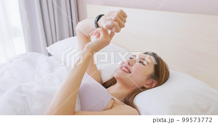 Woman wake up with smartwatch Woman wake up with smartwatch 99573772