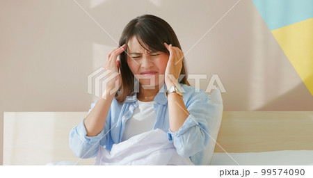 woman has headache on bed woman has headache on bed 99574090