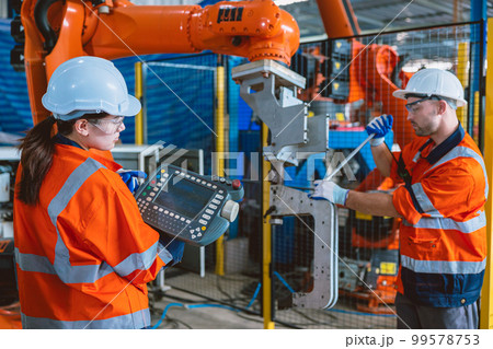 engineer team worker service  robot arm assembly machine in modern metal industry factory 99578753