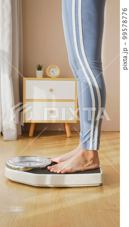 woman measure weight on scale woman measure weight on scale 99578776