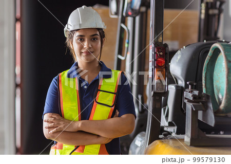 Indian woman staff worker engineer supervisor in safety suit work in factory warehouse 99579130