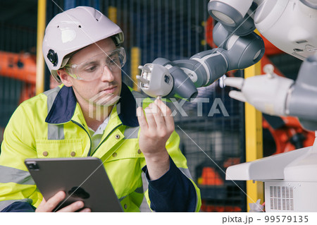 professional engineer male caucasian working with automated robotic arm for modern industry factory technology professional engineer male caucasian working with automated robotic arm for modern industry factory technology 99579135